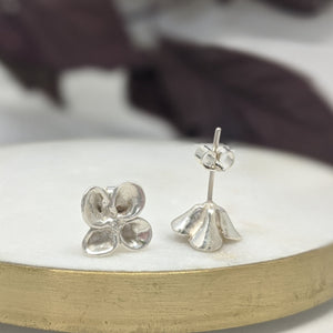 Flower stud earring made from recycled silver.