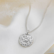 Load image into Gallery viewer, Circular silver pendant with fossil texture on a silver curb chain.
