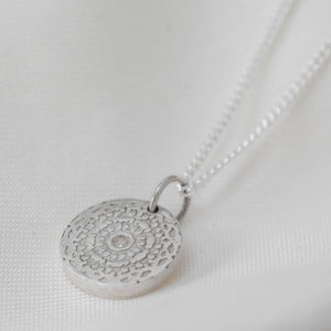 Silver aztec style circular coin pendant on a silver curb chain.
